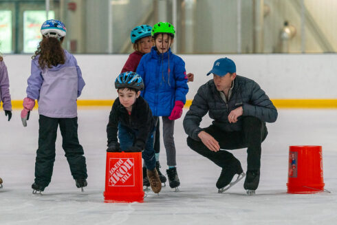instructor with beginner skaters