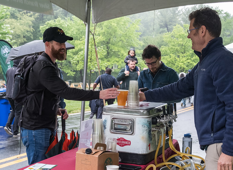 Attendee smiles as they grab a cup of beer from a vendor