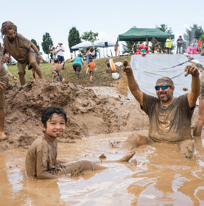 Dad and child play in mud pool