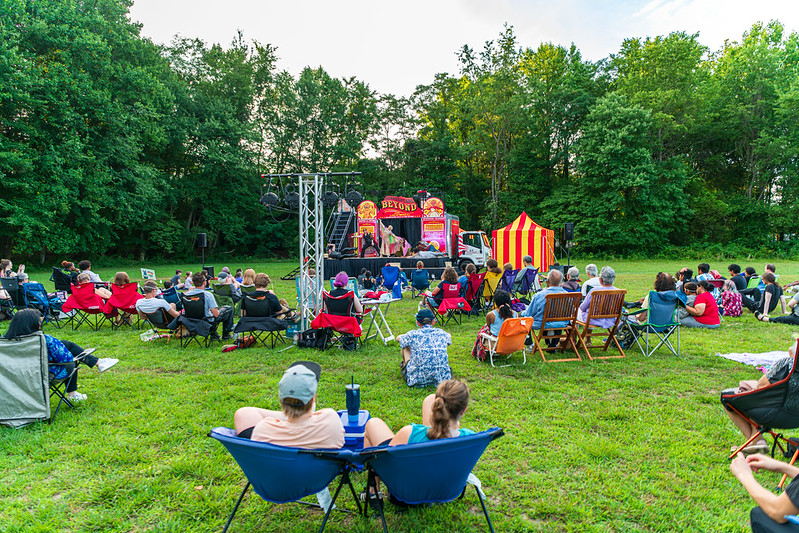Crowd sitting on grassy lawn at Shakespeare Beyond 2024
