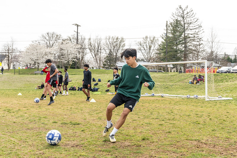 A young adult practicing soccer